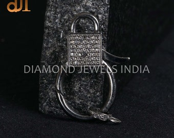May include: A silver padlock charm with a clear crystal design. The padlock is attached to a silver ring with a hook.