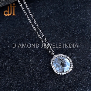 May include: A silver chain necklace with a large, oval-shaped pendant. The pendant features a clear, faceted gemstone surrounded by a halo of smaller, sparkling gemstones.