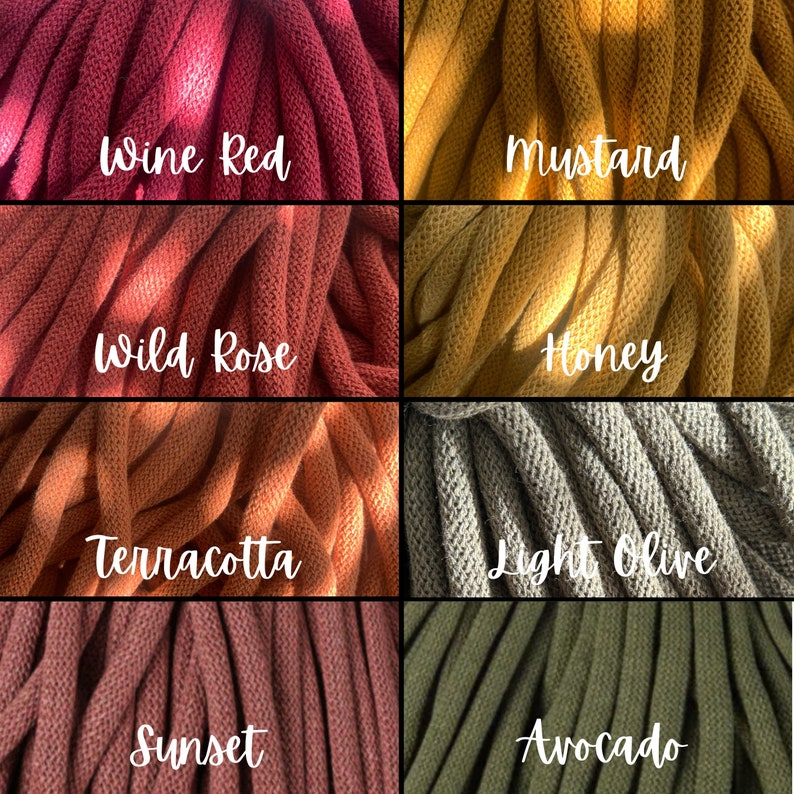 Op de afbeelding: Close-up van acht verschillende gekleurde garenmonsters. Kleuren zijn wijnrood, mosterd, wilde roos, honing, terracotta, licht olijfgroen, zonsondergang en avocado. Elk monster heeft een handgeschreven label met de kleurnaam.
