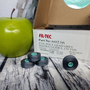 May include: A box of gray thread spools labeled "FIL-TEC Part No: 60236 PISL POLY LEAD GREY MAGNA-GLIDE L 130 YDS 199AH 1991810 Inventory Unit: 72.000 Unit: 72.000 KOLDEN BOX".