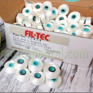 May include: A box of white thread spools with blue centers. The box is labeled "FIL-TEC" and "Part No: 12434 PISL POLY WHITE MC MAGNA-GLIDE 135 YDS 275AG 2751712".