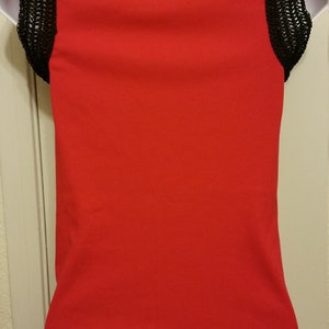 May include: A red sleeveless top with black crochet trim around the neckline and on the sleeves.