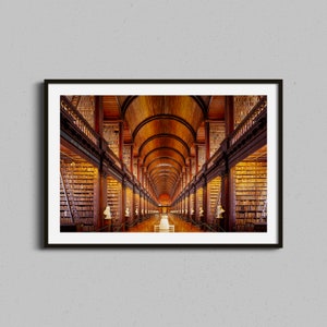 May include: A long, narrow library with high ceilings and wooden bookshelves filled with books. The shelves are arranged in a symmetrical pattern, creating a sense of grandeur and order. The room is lit by natural light streaming in from windows at the end of the hall.