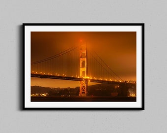 May include: A photograph of the Golden Gate Bridge in San Francisco, California. The bridge is illuminated with warm, orange lights, and the sky is a hazy orange color. The bridge is a popular tourist destination and a symbol of the city.