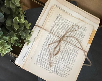 May include: A stack of vintage dictionary pages tied together with twine. The pages are yellowed with age and have a worn, rustic look. The dictionary pages are from the 1940s and feature words like "avalanche" and "dissimilar".