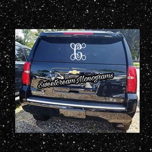 May include: A black SUV with a white monogram decal on the back window. The decal says "Sweetcream Monograms".