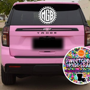 May include: A pink Chevrolet Tahoe with a white monogram decal on the back window. The decal says "MGB" in a circle with white dots around it. The car has a sticker on the back bumper that says "Sweetcream Monograms Shreveport, Louisiana" with a colorful sprinkle design and a small Etsy logo.