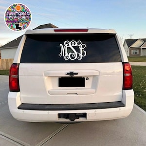May include: White SUV with a white monogram decal on the rear window. The monogram is "MSL".