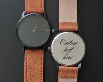 May include: Two brown leather wristwatches with black faces. The watch on the left has a black face with white hands and a red second hand. The watch on the right has a white face with black text that says "Custom text here".