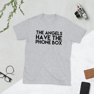 May include: A heather grey t-shirt with black text that reads "THE ANGELS HAVE THE PHONE BOX".