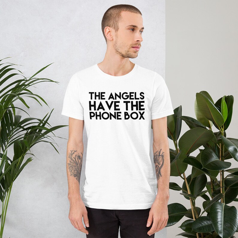 May include: White t-shirt with black text that reads "THE ANGELS HAVE THE PHONE BOX"