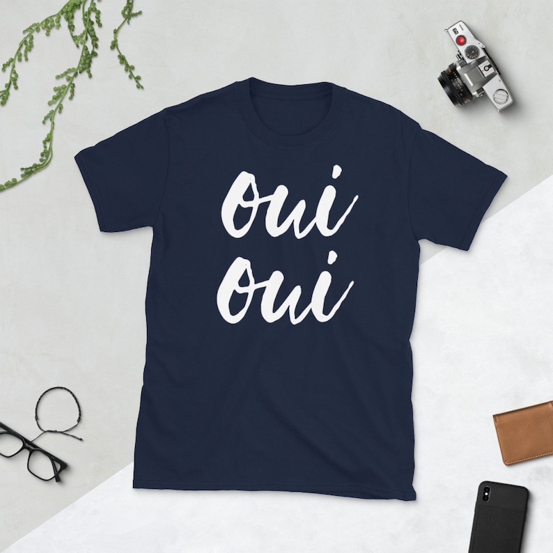 May include: A navy blue t-shirt with the text "oui oui" written in white cursive.