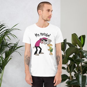 May include: White t-shirt with a cartoon image of a wolf and a rabbit. The wolf is saying "Ну, погоди!" in Russian.