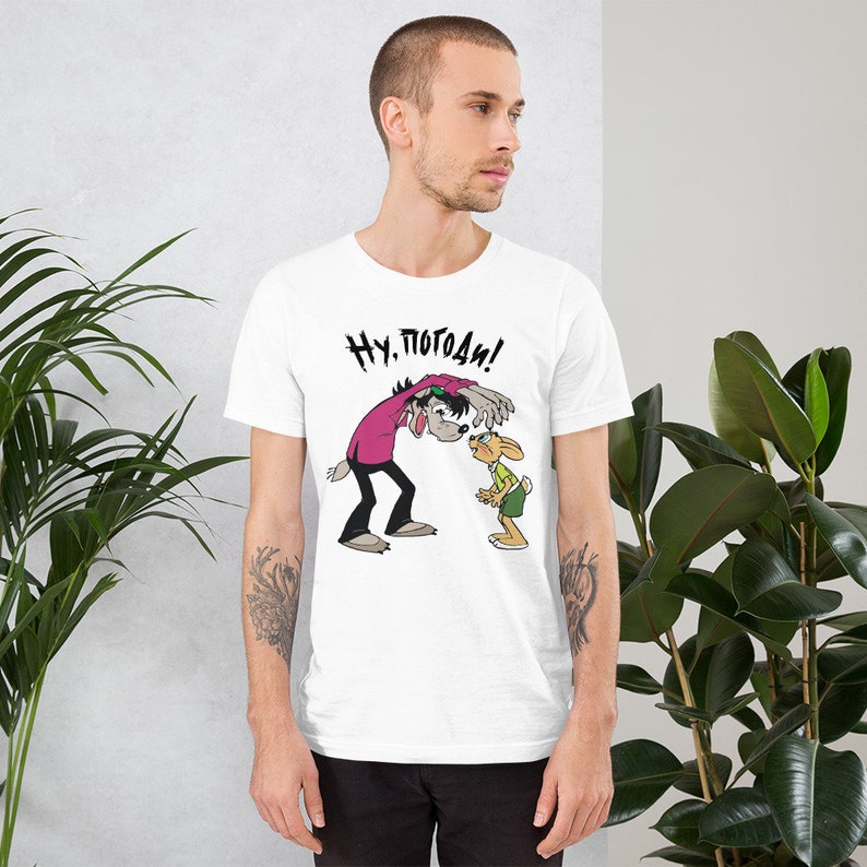 May include: White t-shirt with a cartoon image of a wolf and a rabbit. The wolf is saying "Ну, погоди!" in Russian.