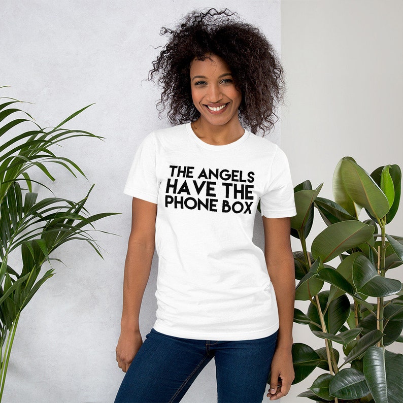 May include: White t-shirt with black text that reads "THE ANGELS HAVE THE PHONE BOX"