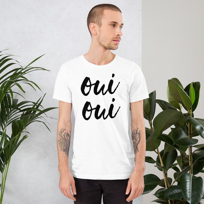 May include: White t-shirt with black text that says "oui oui" in a cursive font.