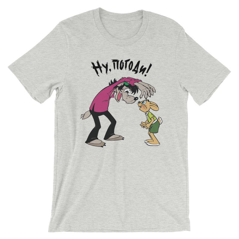 May include: A grey t-shirt with a cartoon wolf and rabbit. The wolf is saying "Ну, погоди!" in Russian.