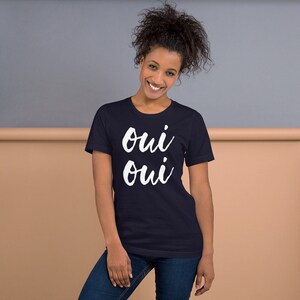 May include: A navy blue t-shirt with the words "oui oui" written in white cursive.