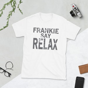 Può includere: Maglietta bianca con una grafica grigia usurata che dice "Frankie Say Relax".