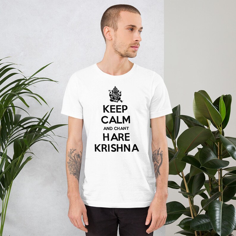 May include: White t-shirt with a black graphic of a Hindu deity and the text "Keep Calm and Chant Hare Krishna".