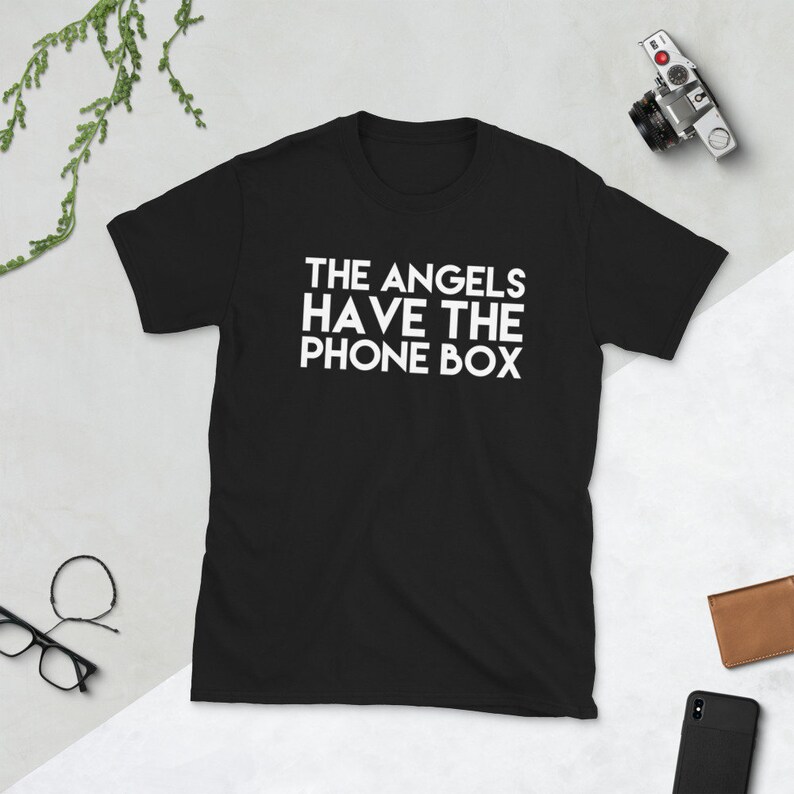 May include: Black t-shirt with white text that reads "THE ANGELS HAVE THE PHONE BOX"