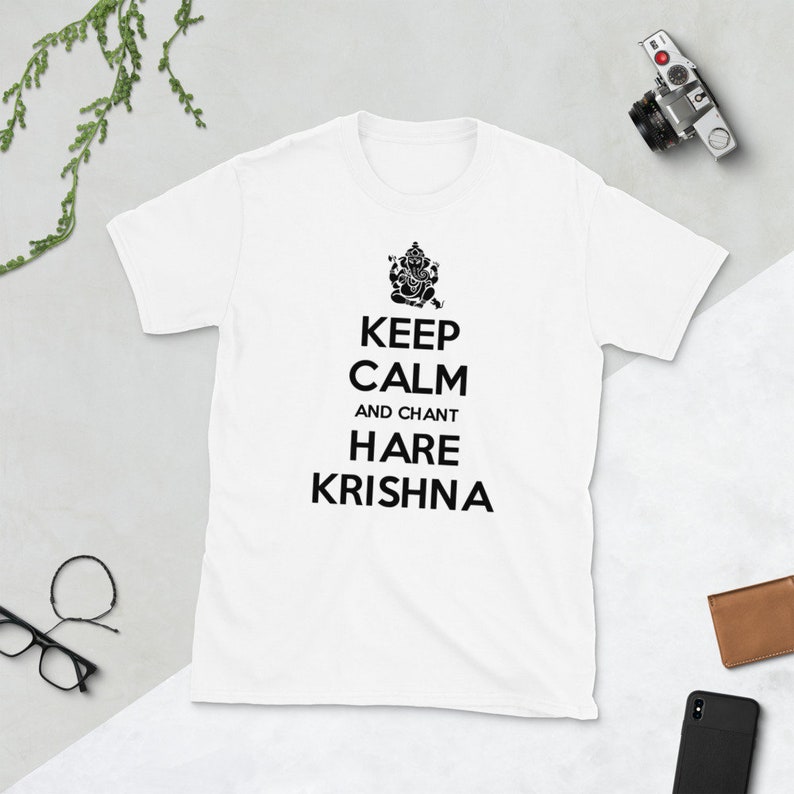 May include: White t-shirt with black text that reads "Keep Calm and Chant Hare Krishna". A black and white image of a Hindu deity is above the text.