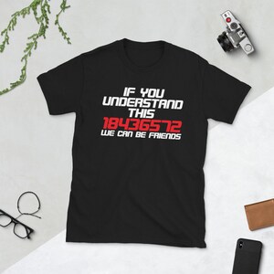 以下が含まれることがあります： 白い文字で「If you understand this 18436572 we can be friends」と書かれた黒いTシャツ。数字の18436572は赤色です。