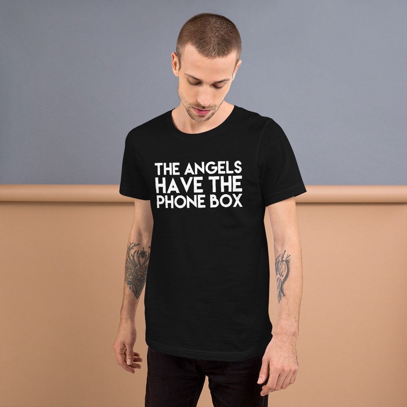 May include: Black t-shirt with white text that reads "THE ANGELS HAVE THE PHONE BOX"