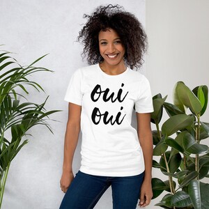 May include: White t-shirt with the text "oui oui" printed in black.