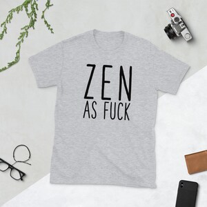May include: A gray t-shirt with black text that reads "ZEN AS FUCK".