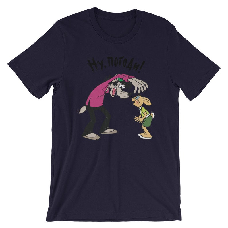 May include: A navy blue t-shirt with a cartoon image of a wolf and a rabbit. The wolf is wearing a pink shirt and has the text "Ну, погоди!" above it.