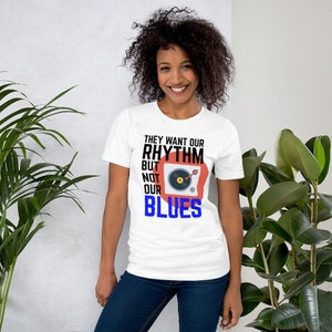 May include: White t-shirt with a black and red graphic of a record player and the text "They want our rhythm but not our blues".