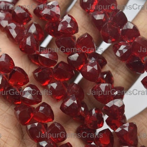 Puede incluir: Una hebra de cuentas de piedras preciosas facetadas rojas. Las cuentas tienen forma de lágrima y un acabado brillante y pulido.