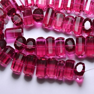 May include: A strand of pink faceted glass beads. The beads are strung on a thin wire and are all the same size and shape.