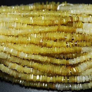 May include: A strand of yellow and white gemstone beads. The beads are rectangular and have a smooth, polished finish.