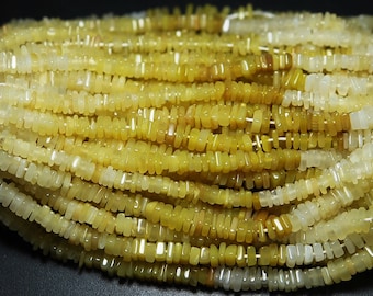May include: A strand of yellow and white gemstone beads. The beads are rectangular and have a smooth, polished finish.