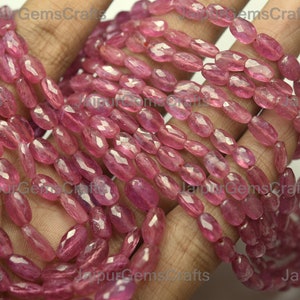 以下が含まれることがあります： ピンクのルビーの宝石ビーズのストランドで、ファセットが施され、楕円形です。ビーズは糸に通されており、サイズは約6mmです。