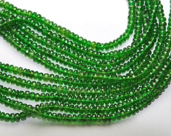 May include: A strand of green gemstone beads. The beads are faceted and have a shiny finish. The beads are strung on a clear thread.