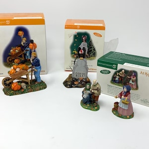May include: A collection of Department 56 Halloween figurines, including a pumpkin patch scene with a wheelbarrow, a tombstone with text, and figures trick-or-treating. The figurines are in their original boxes.