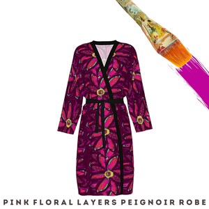 May include: A pink floral print robe with a black sash. The robe has a long, flowing silhouette and a relaxed fit.