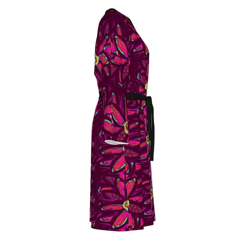 May include: A long-sleeved dress with a floral print in shades of pink, red, and green. The dress has a black belt and a V-neck.