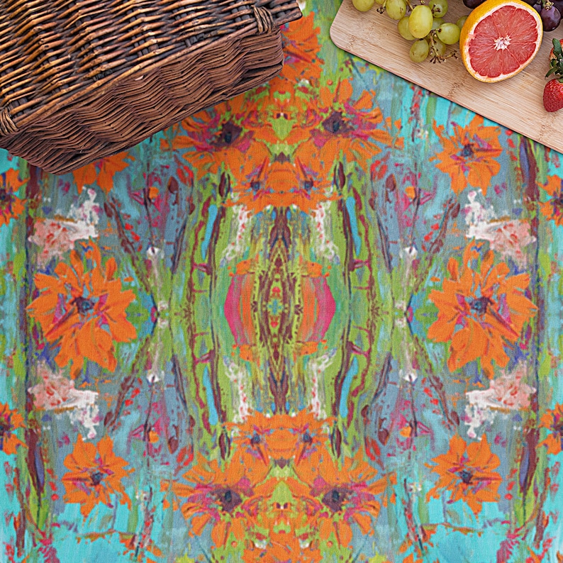 May include: A colorful picnic blanket with a floral pattern featuring orange flowers and green leaves on a turquoise background.