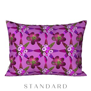 May include: A purple pillow with a repeating pattern of pink and green flowers. The pillow is a standard size.