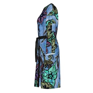 May include: A blue dress with a colorful floral pattern and a black belt. The dress has a long sleeve and a knee-length hem.