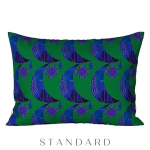 May include: A green pillow with a repeating pattern of blue crescent moons and purple stars. The pillow is a standard size.