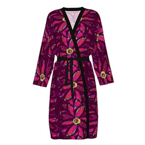 May include: A long, burgundy robe with a black sash and a floral print featuring pink and green flowers.