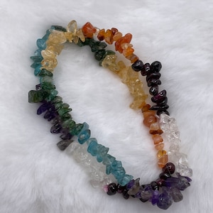 May include: A rainbow-colored gemstone bracelet with chips of amethyst, clear quartz, aquamarine, green aventurine, citrine, carnelian, and red jasper.