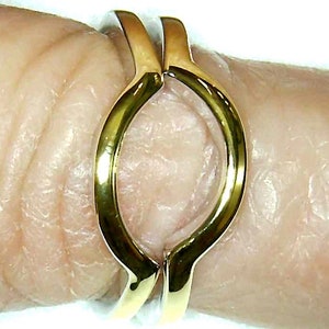 May include: A gold-toned ring with a unique open design, perfect for stacking with other rings.