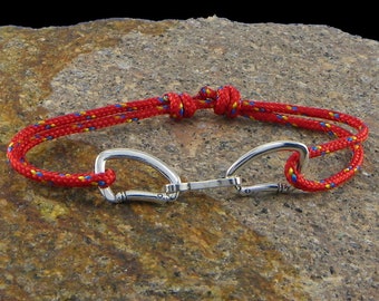 May include: Red and blue rope bracelet with a silver carabiner clasp.