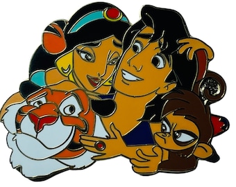May include: A colorful enamel pin featuring Aladdin, Jasmine, Abu, and Rajah from the Disney movie Aladdin. The characters are depicted in a close-up, with Aladdin holding Abu and Jasmine holding Rajah.